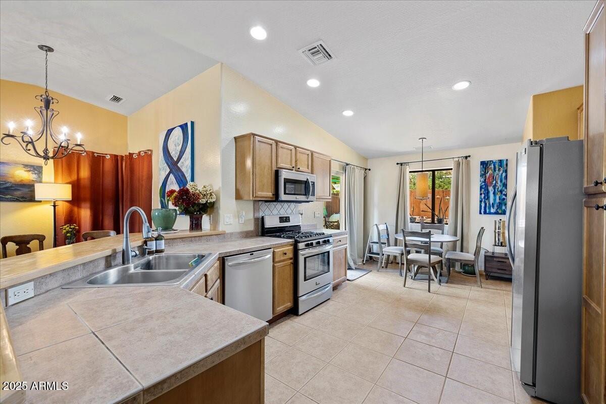 4580 East Steven Way Rimrock, AZ 86335 - Photo 6 of 17 a kitchen with stainless steel appliances granite countertop a stove top oven a sink dishwasher a dining table and chairs with wooden floor