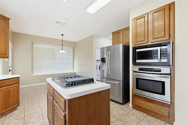 a kitchen with granite countertop a refrigerator and a stove top oven