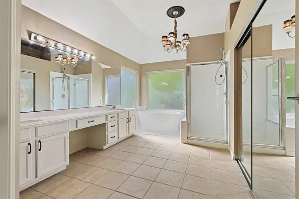 a large bathroom with a glass door shower a sink and a mirror