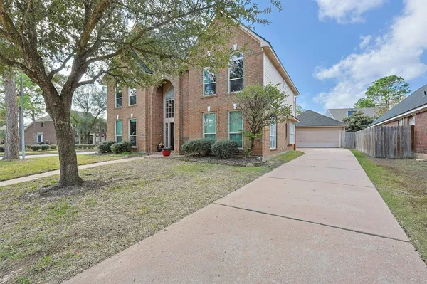 a front view of a house with a yard and trees