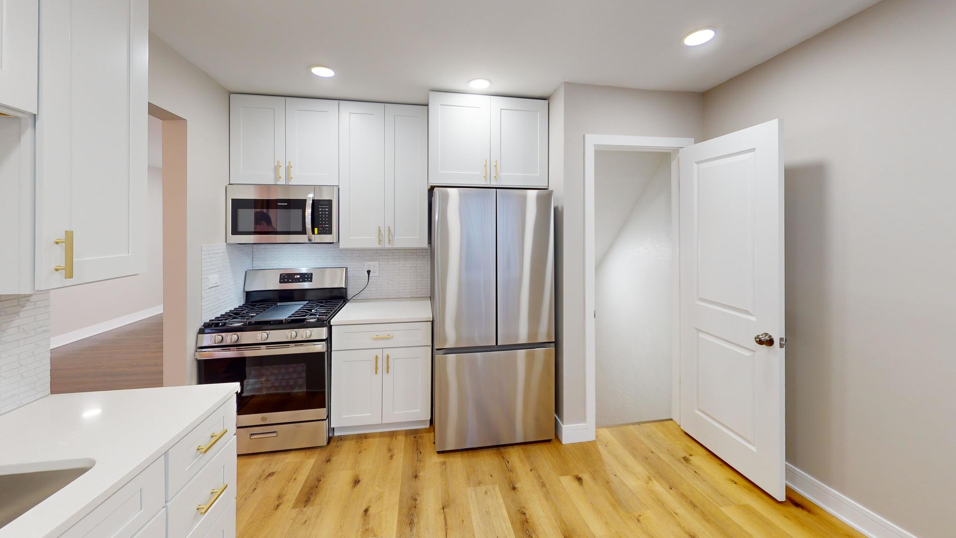 1321 Pitner Avenue, Unit A Evanston, IL 60201 - Photo 12 of 35 a kitchen with a refrigerator a stove top oven and wooden floor