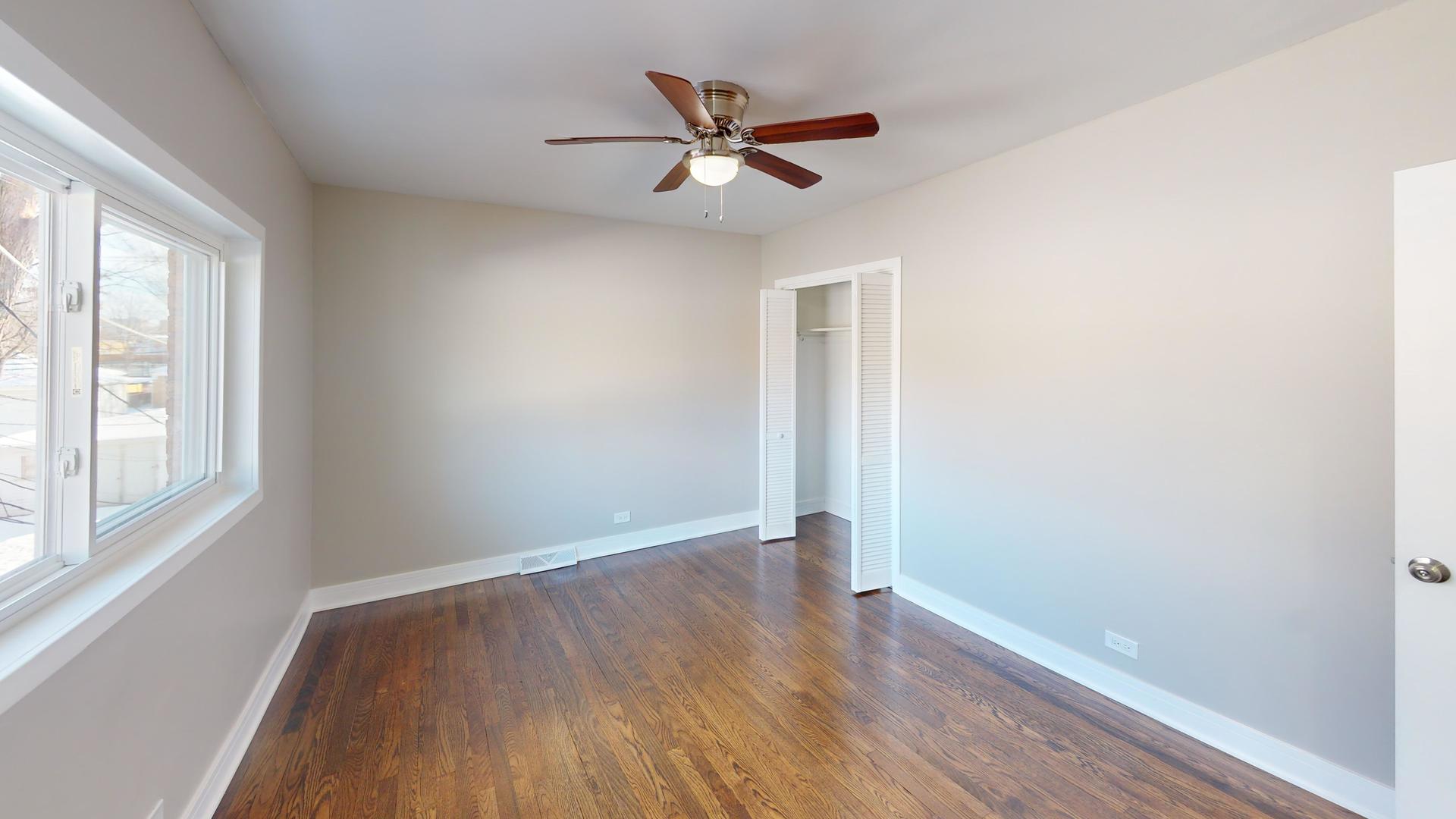 1321 Pitner Avenue, Unit A Evanston, IL 60201 - Photo 20 of 35 an empty room with wooden floor fan and windows