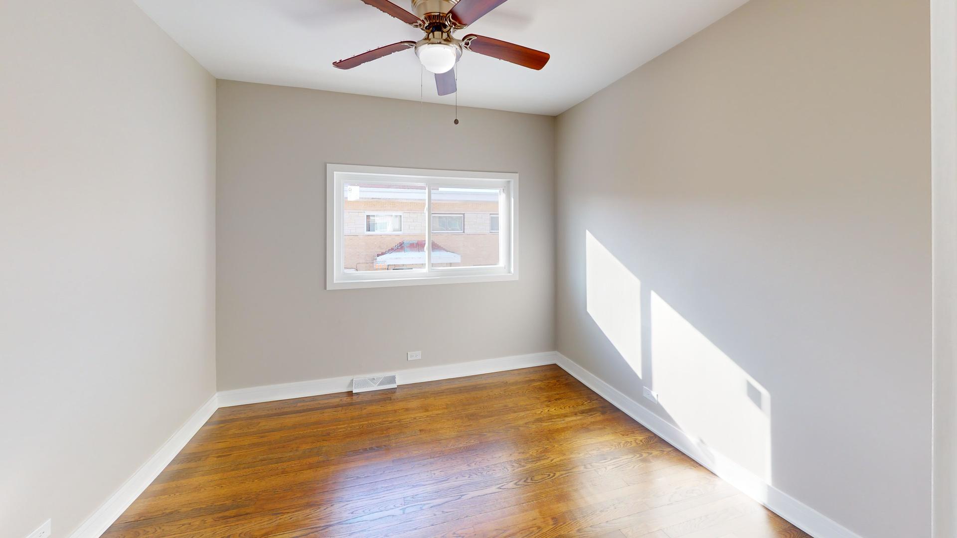 1321 Pitner Avenue, Unit A Evanston, IL 60201 - Photo 30 of 35 an empty room with wooden floor fan and windows
