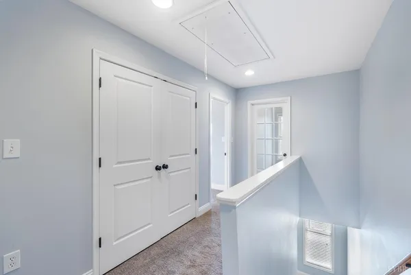 a view of an empty room with closet and a window