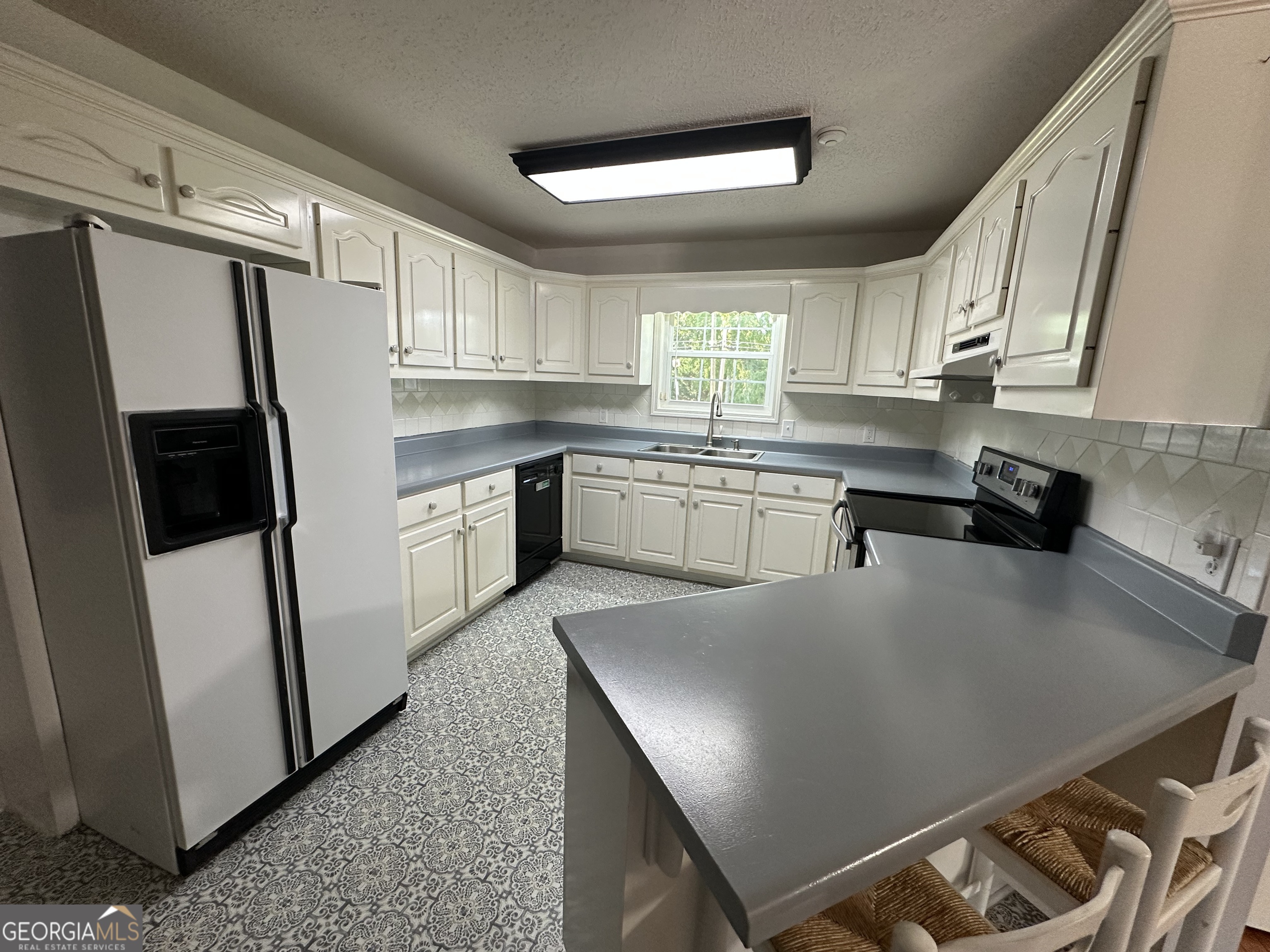 384 Sam Brown Boulevard Commerce, GA 30529 - Photo 10 of 25 a kitchen with stainless steel appliances granite countertop a refrigerator a sink dishwasher a stove and white countertops with wooden floor