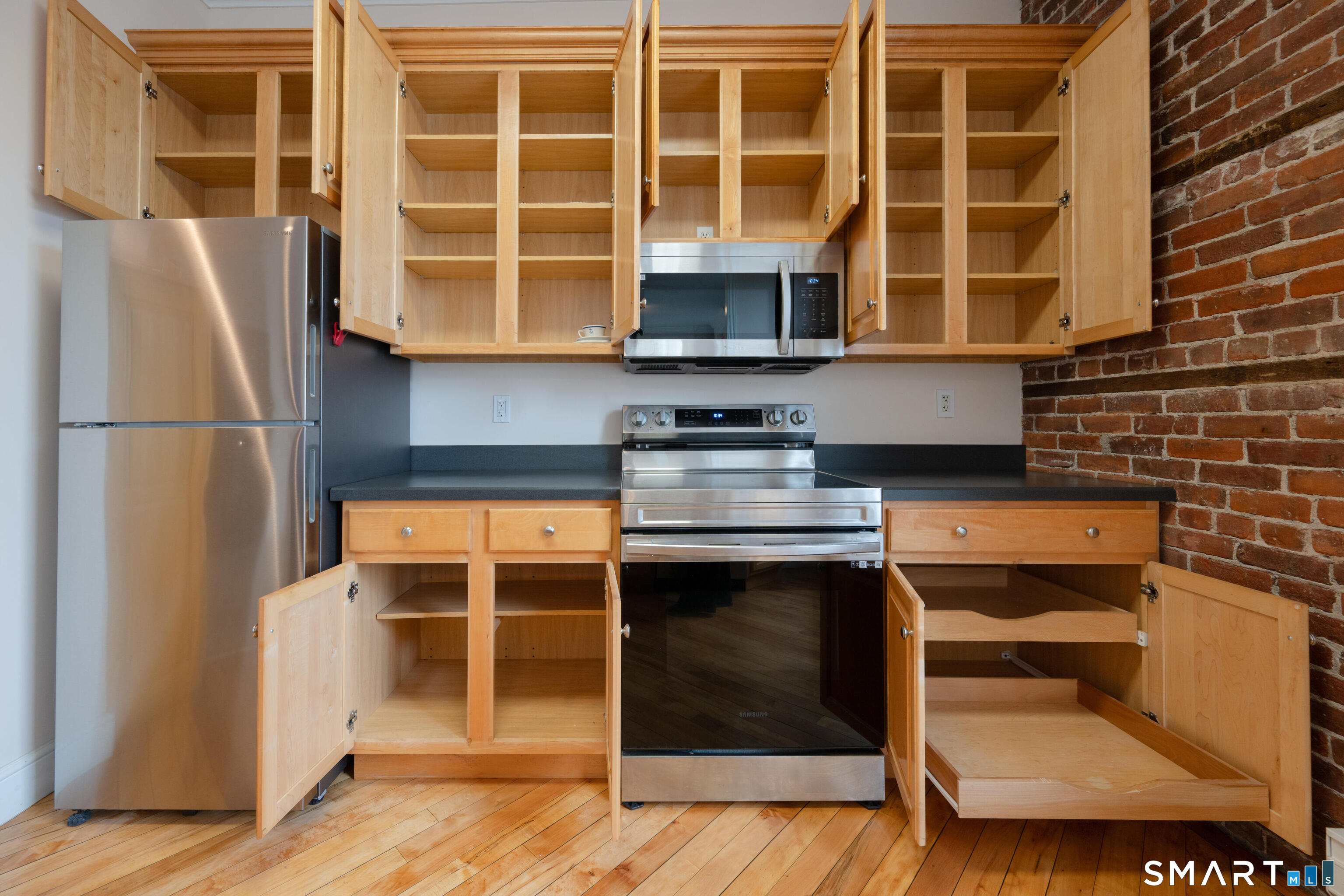 130 Main Street, Unit 2D Canton, CT 06019 - Photo 12 of 25 a kitchen with stainless steel appliances granite countertop a stove and a refrigerator
