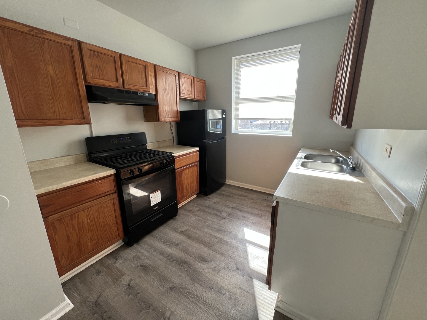 2047 East 68th Street, Unit 3W Chicago, IL 60649 - Photo 5 of 6 a kitchen with granite countertop a sink stove and refrigerator