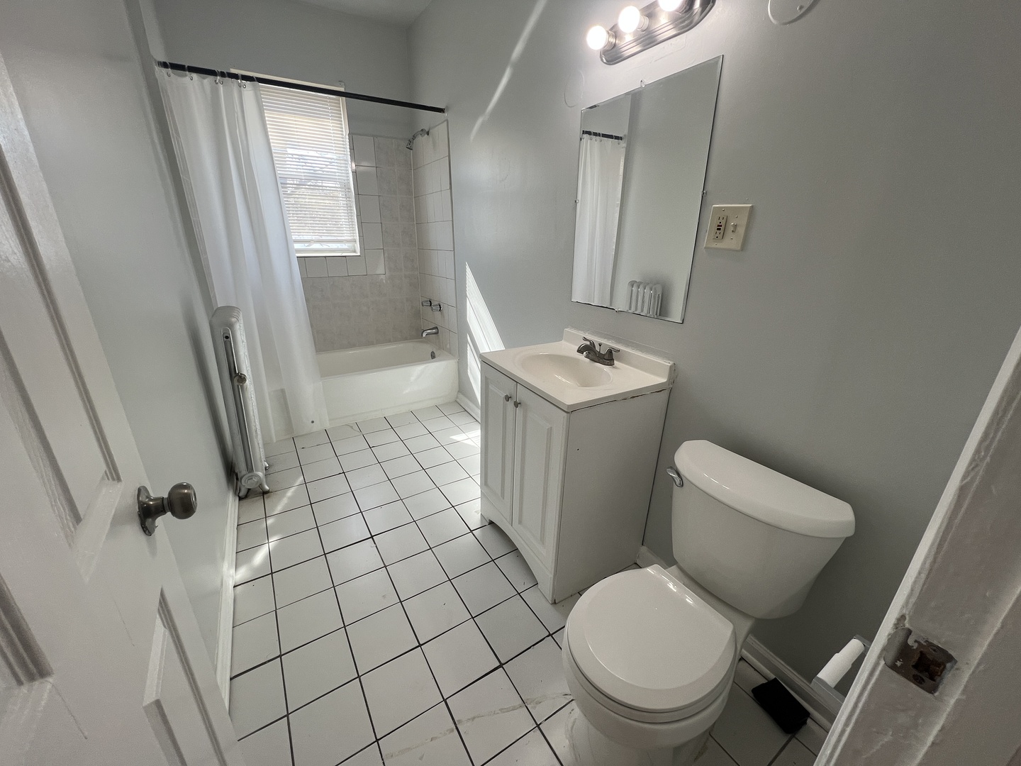 2047 East 68th Street, Unit 3W Chicago, IL 60649 - Photo 6 of 6 a white toilet sitting next to a bathroom sink and a mirror