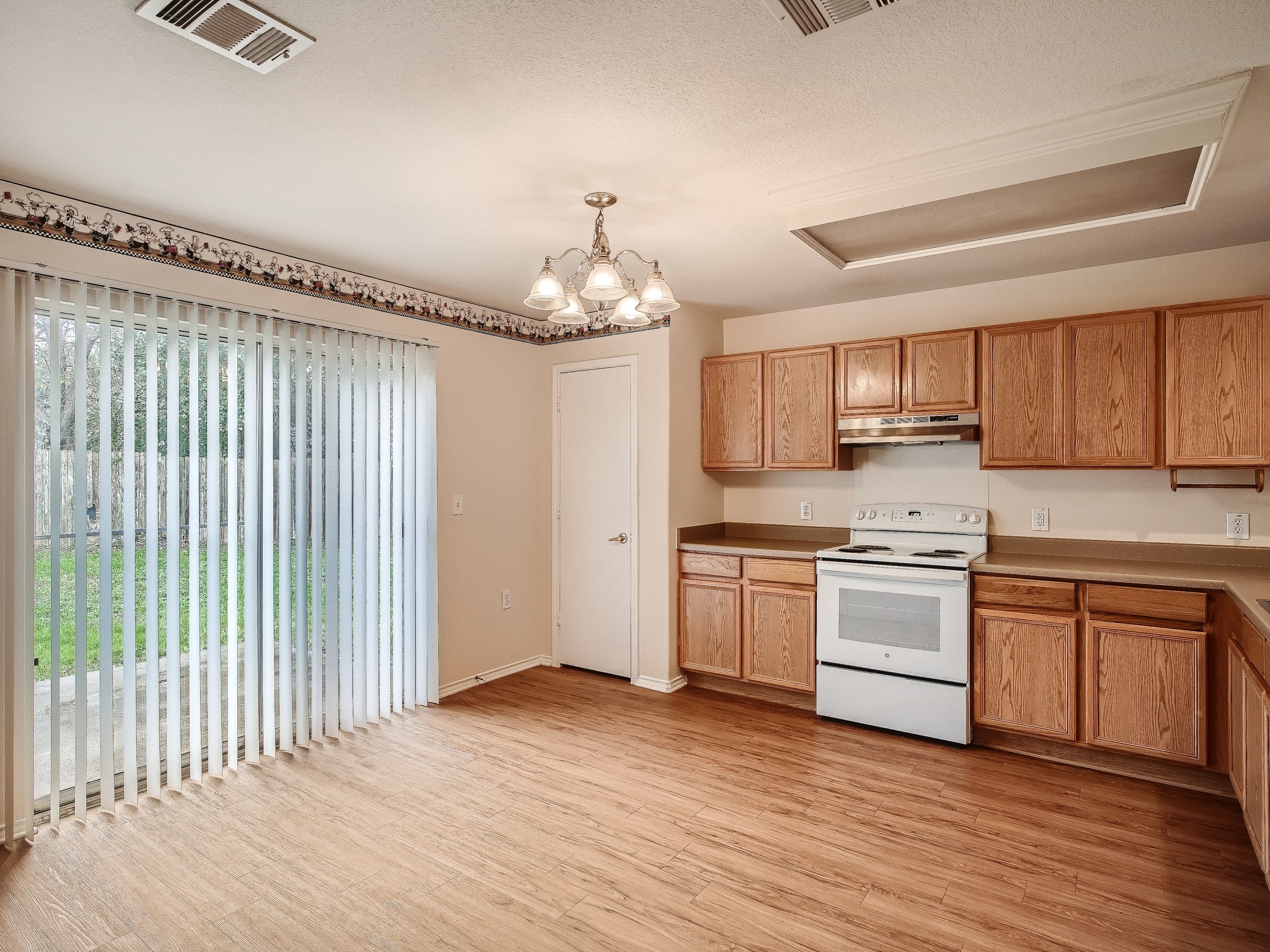 2002 Nogales Trail Austin, TX 78744 - Photo 6 of 16 a kitchen with granite countertop a stove cabinets and wooden floor