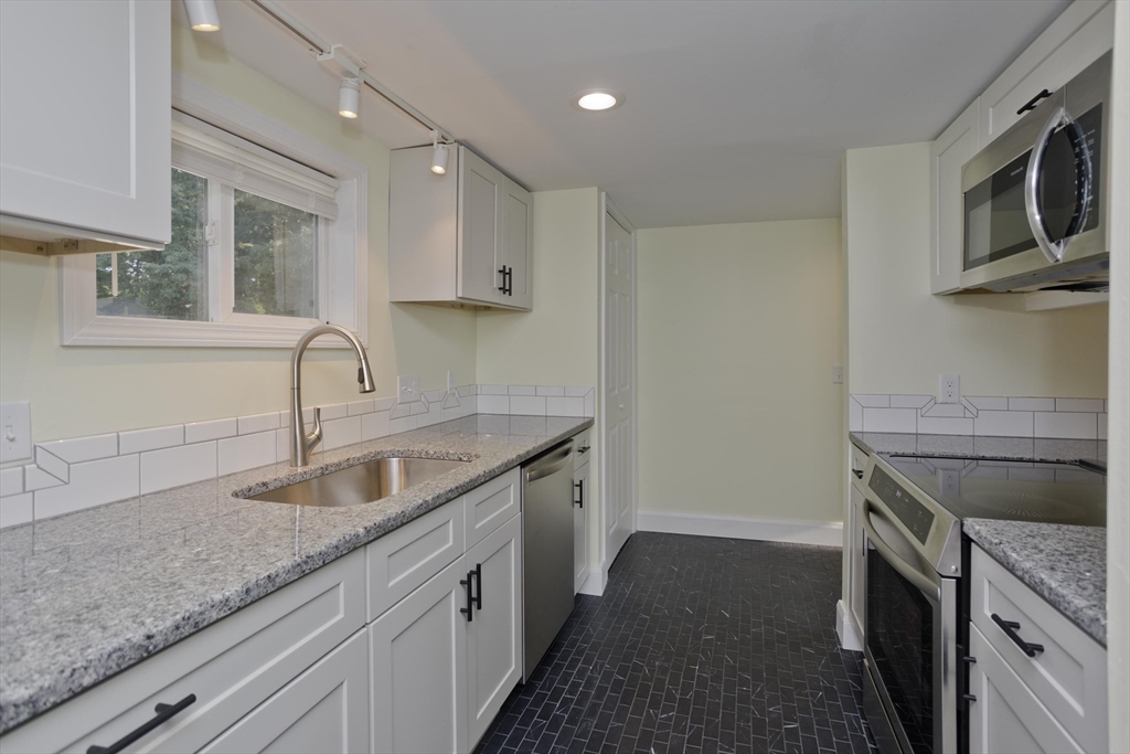 265 Ambrose Street Springfield, MA 01109 - Photo 3 of 24 a kitchen with granite countertop a sink stove and cabinets