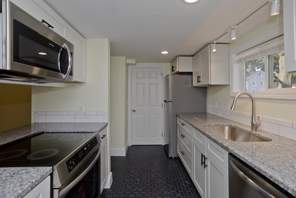 265 Ambrose Street Springfield, MA 01109 - Photo 4 of 24 a kitchen with granite countertop a sink stainless steel appliances and cabinets