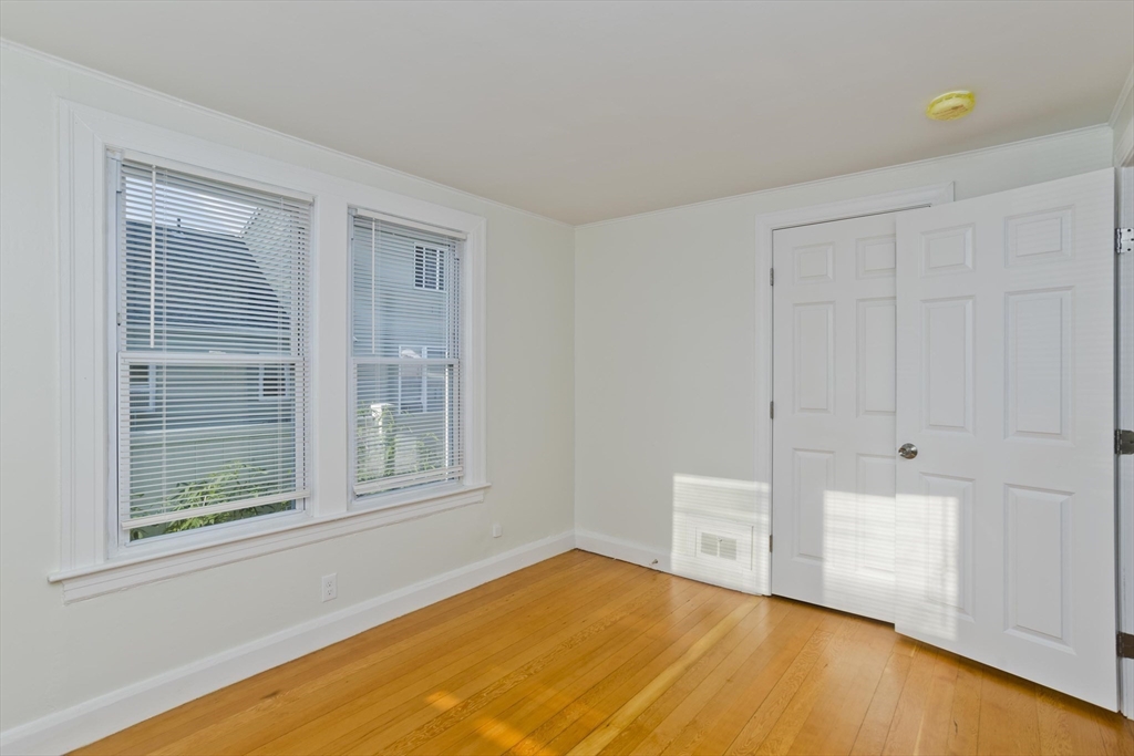 265 Ambrose Street Springfield, MA 01109 - Photo 7 of 24 a view of an empty room with a window and wooden floor