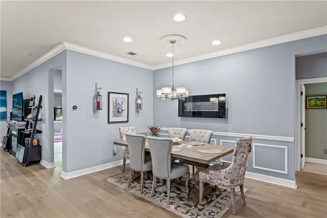 a kitchen with a stove a refrigerator and a dining table with wooden floor