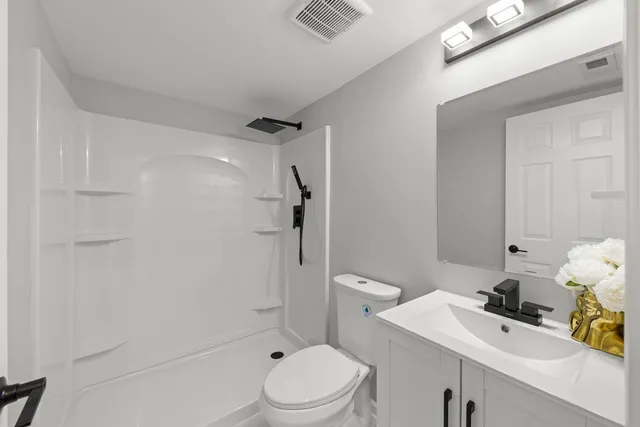 a bathroom with a sink toilet and shower