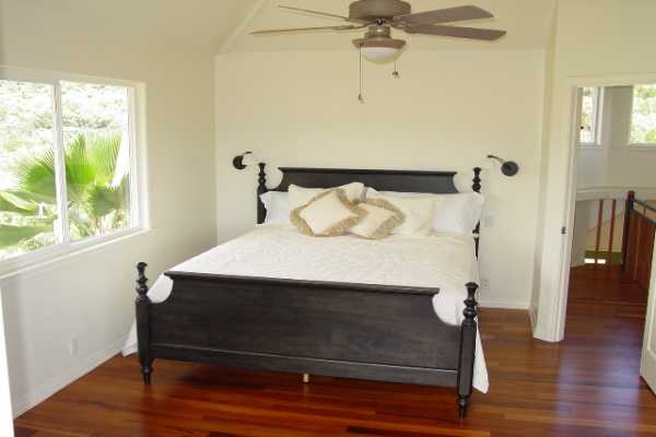 6867 Koolau Road Kilauea, HI 96754 - Photo 7 of 8 a bedroom with a bed and a window