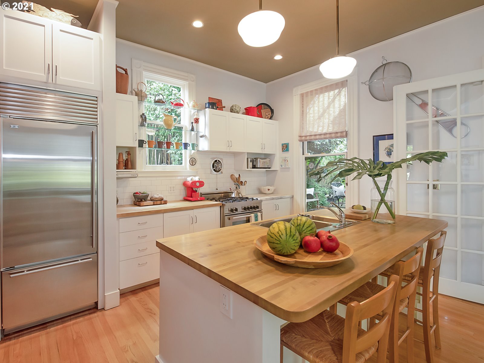 124 Southwest Meade Street Portland, OR 97201 - Photo 10 of 32 a kitchen with a refrigerator a stove and a dining table with wooden floor