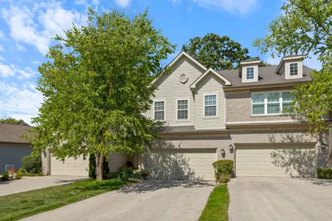 a front view of a house with a yard and a garage