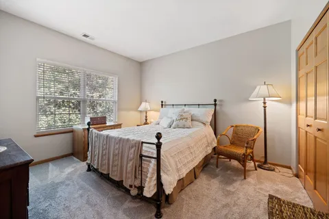 a bedroom with a bed chair and window