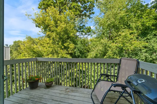 a balcony with wooden floor and outdoor seating