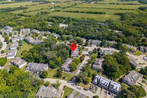 an aerial view of residential houses with outdoor space and trees