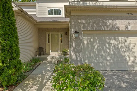 a front view of a house with a yard and fountain in middle