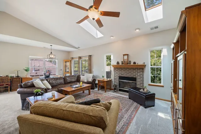 a living room with furniture a fireplace and a chandelier
