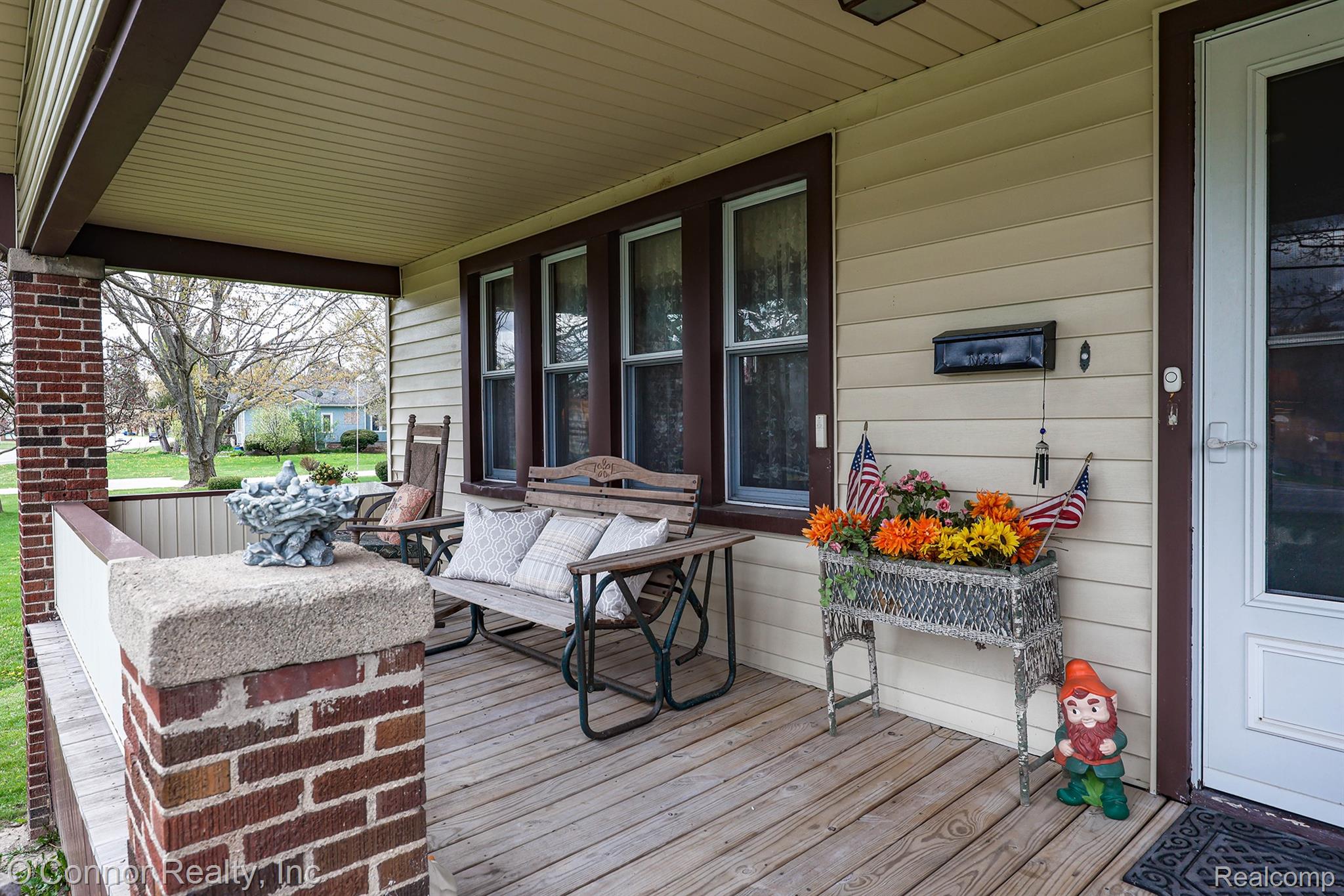 3323 Kinney Road Emmett, MI 48022 - Photo 2 of 29 Inviting covered front porch featuring wood flooring, brick pillars, vinyl siding, and white trim windows