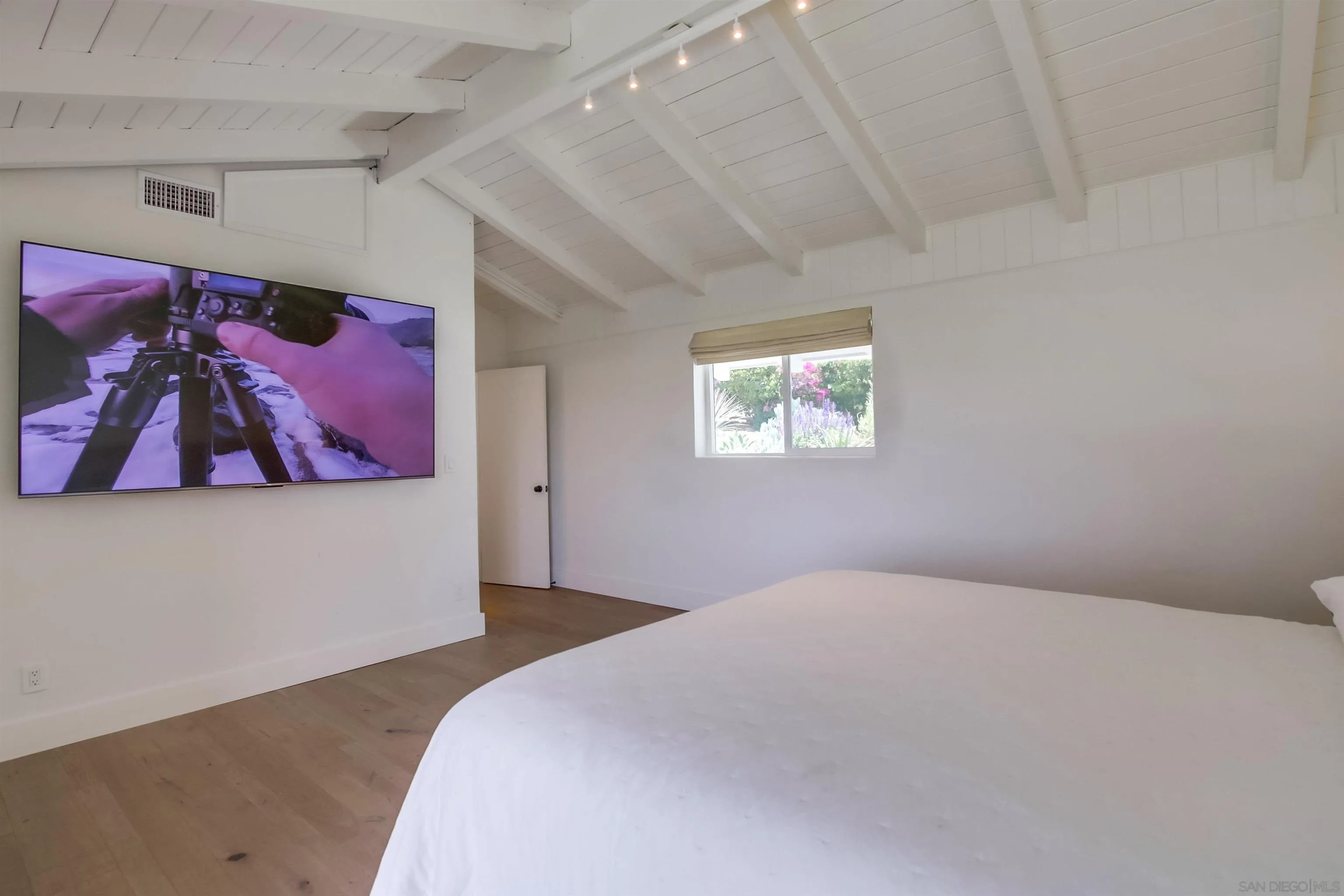 4242 Cosoy Way San Diego, CA 92110 - Photo 28 of 75 a bedroom with a large bed and a painting on the wall