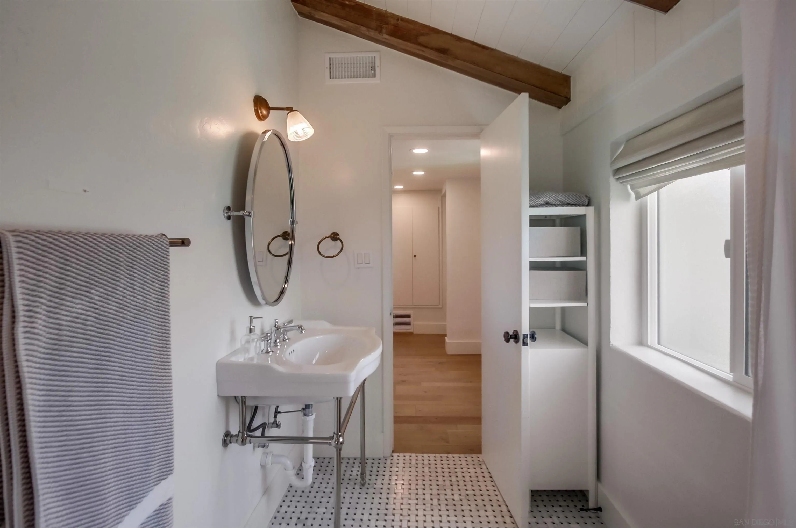 4242 Cosoy Way San Diego, CA 92110 - Photo 36 of 75 a bathroom with a sink a light fixture and a mirror
