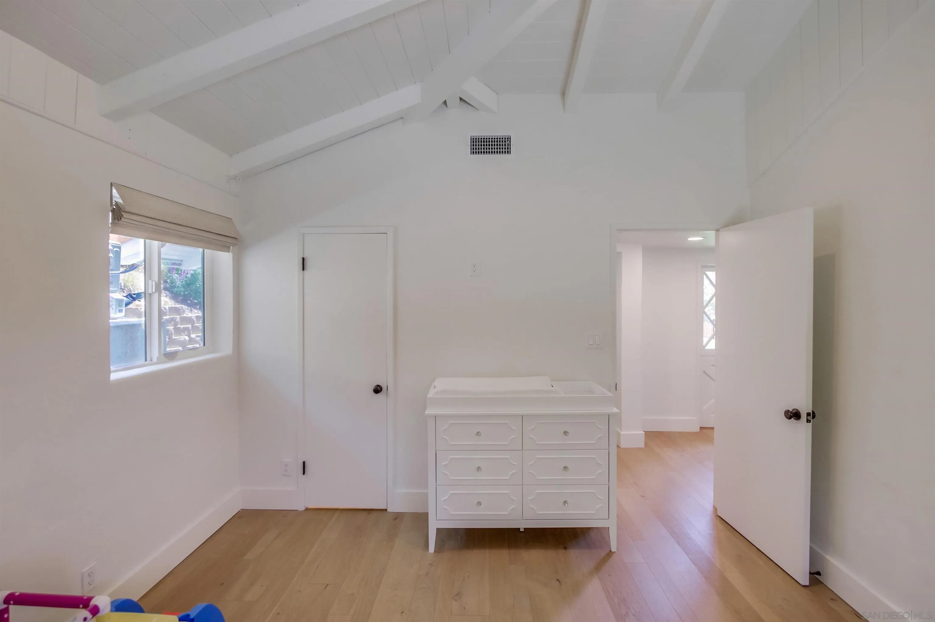 4242 Cosoy Way San Diego, CA 92110 - Photo 41 of 75 an empty room with wooden floor and cabinet