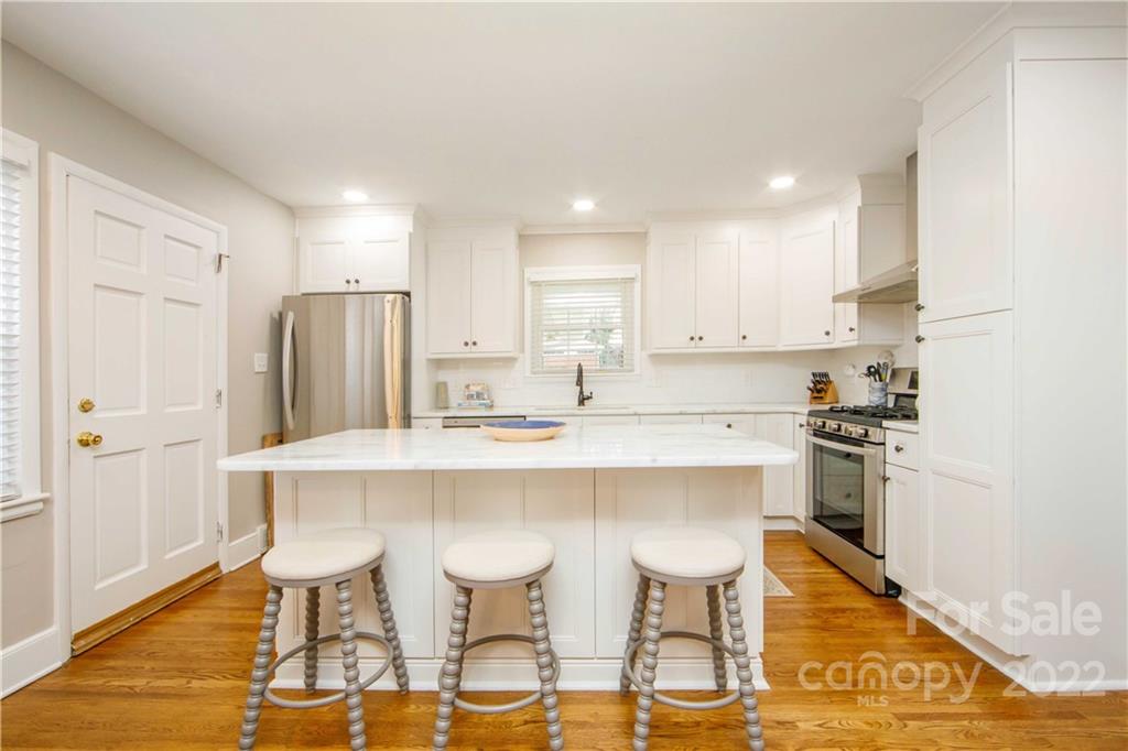 5539 Murrayhill Road Charlotte, NC 28210 - Photo 18 of 46 a kitchen with stainless steel appliances a dining table chairs refrigerator and sink