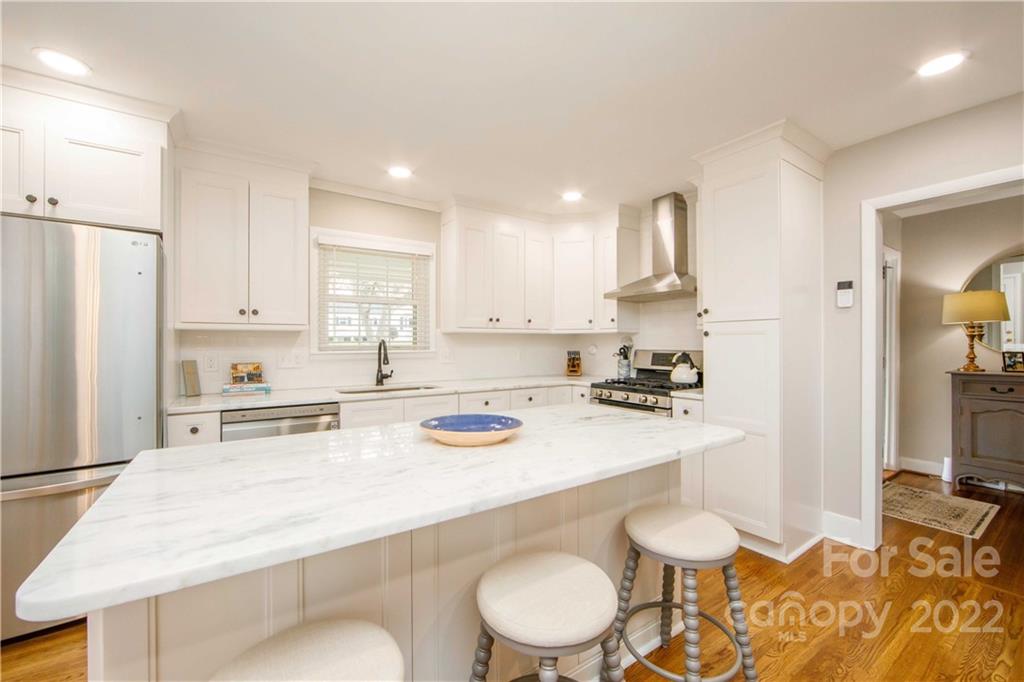 5539 Murrayhill Road Charlotte, NC 28210 - Photo 19 of 46 a kitchen with a sink a stove and white cabinets
