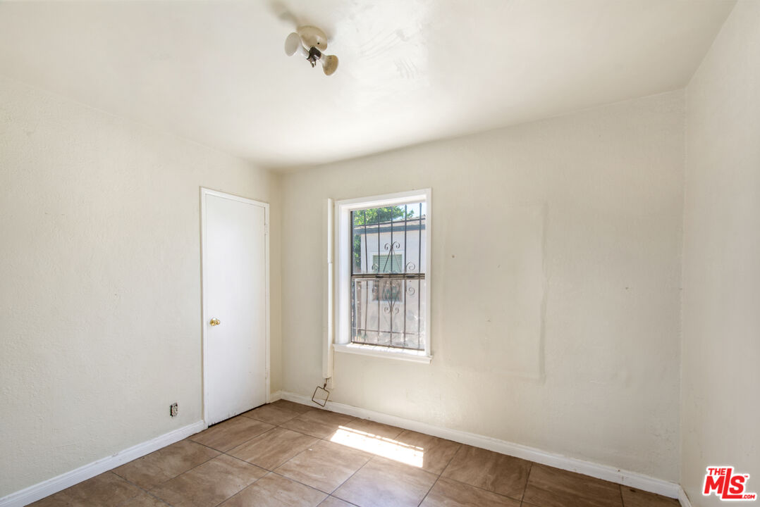 521 South Bullis Road Compton, CA 90221 - Photo 11 of 16 a view of an empty room with wooden floor and a window