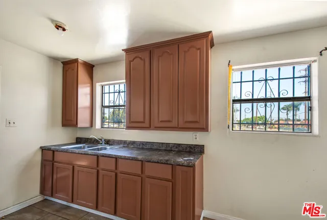 a bathroom with a granite countertop sink and a window