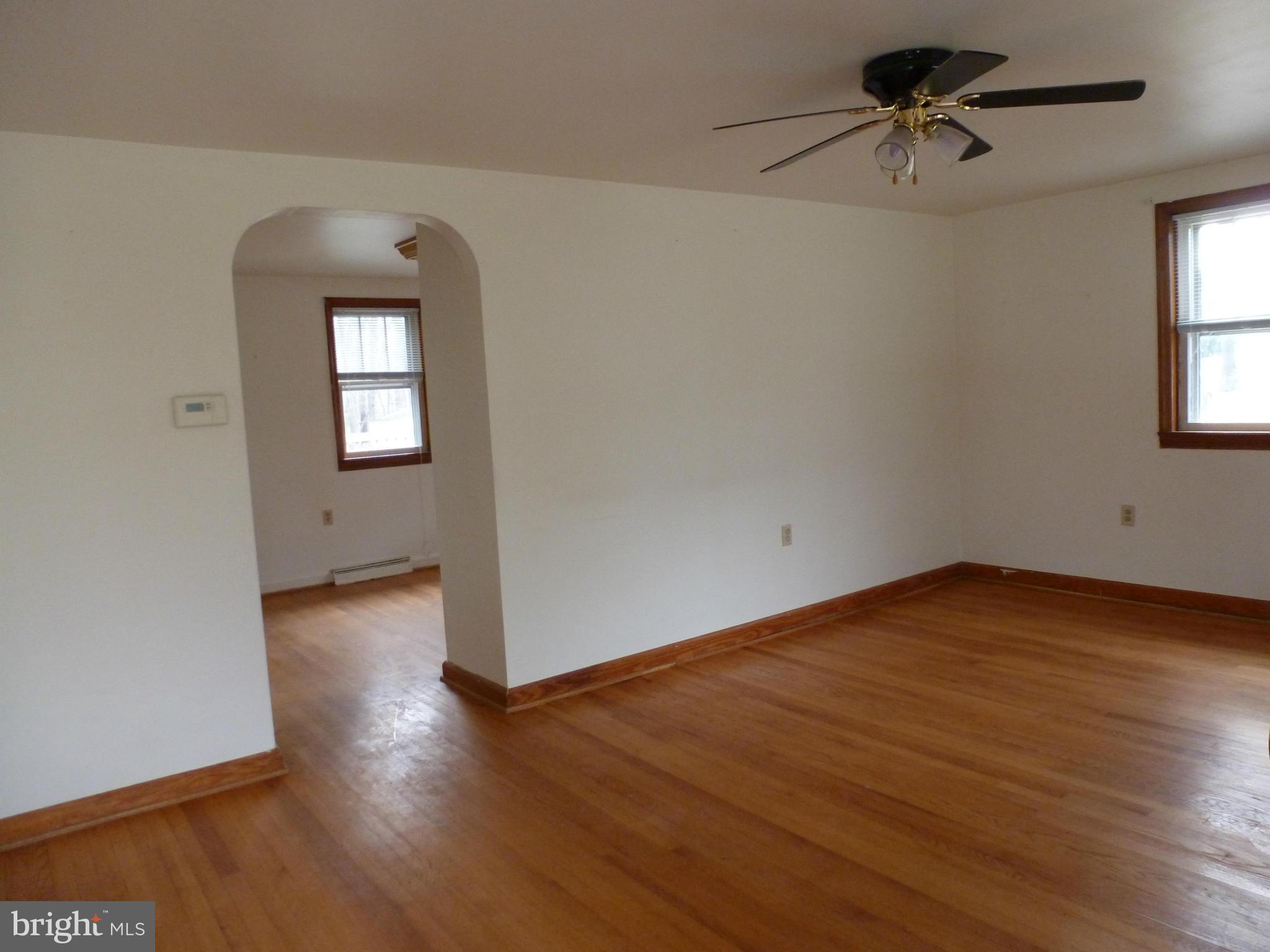 10321 Bethel Road Frederick, MD 21702 - Photo 7 of 18 an empty room with wooden floor chandelier fan and windows