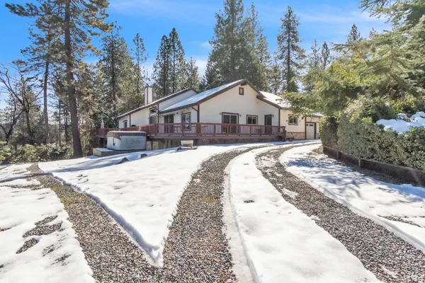 a view of a house with a yard covered in snow