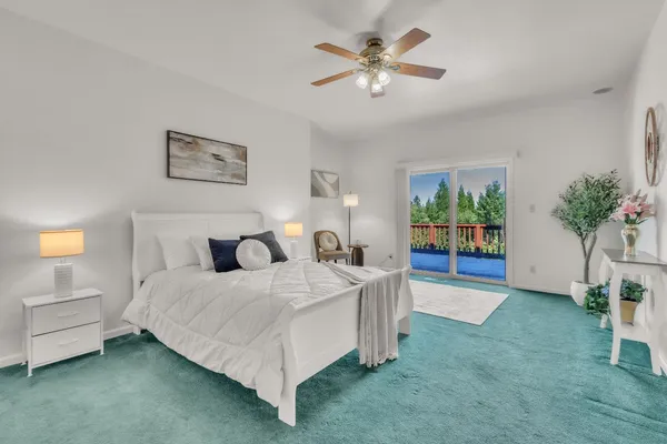 a bedroom with a bed painting on wall and a potted plant