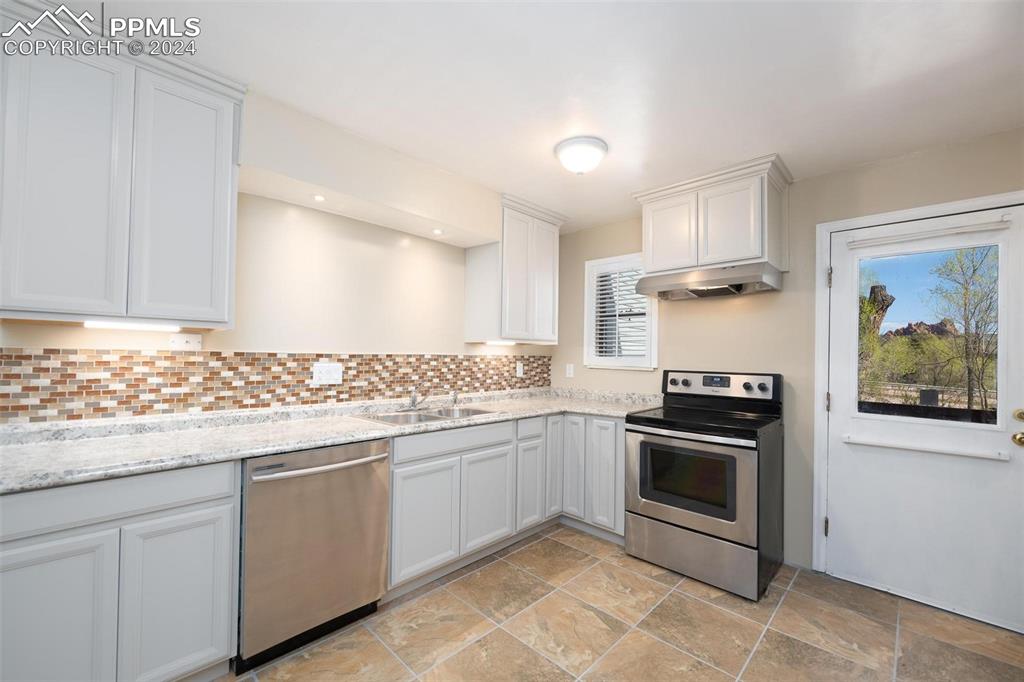 3738 Red Canon Place Colorado Springs, CO 80904 - Photo 2 of 27 a kitchen with stainless steel appliances granite countertop a stove and a sink