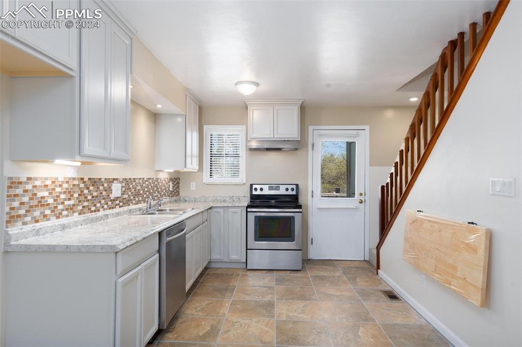 3738 Red Canon Place Colorado Springs, CO 80904 - Photo 3 of 27 a kitchen with a sink stove and cabinets