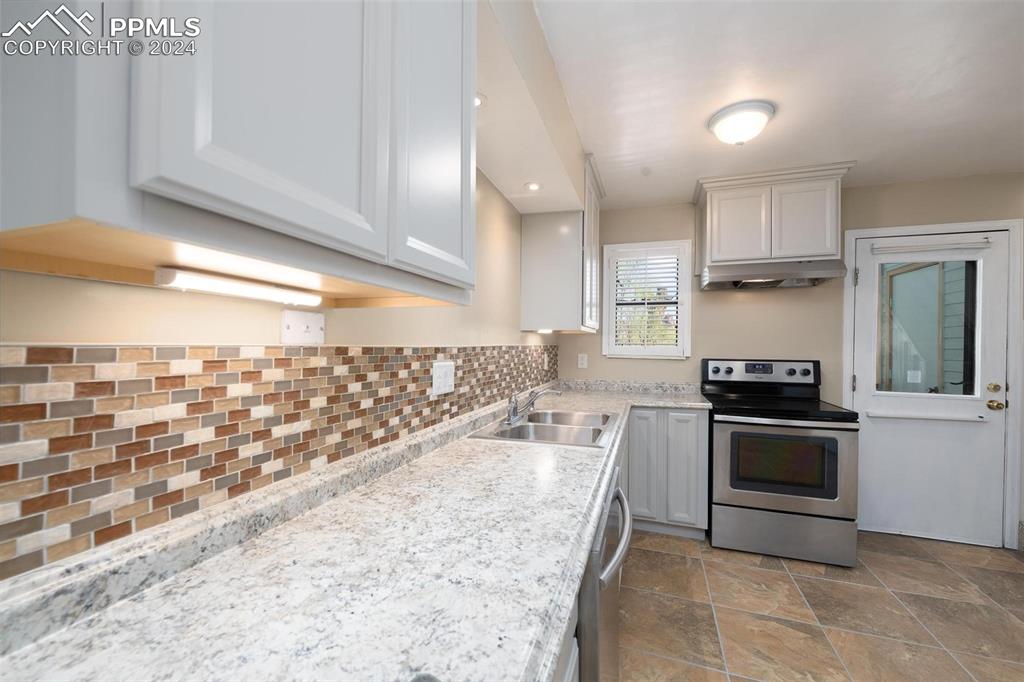 3738 Red Canon Place Colorado Springs, CO 80904 - Photo 4 of 27 a kitchen with granite countertop a stove sink and cabinets