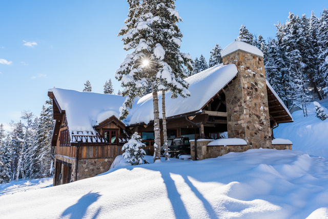 1667 West Tollgate Cyn Road Coalville, UT 84017 - Photo 18 of 61 Stone and wood-sided exterior featuring a prominent stone chimney, a covered outdoor area with exposed beams, and a snow-covered roofline