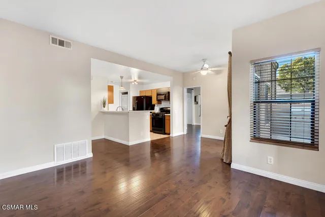 a view of a kitchen with wooden floor and a window
