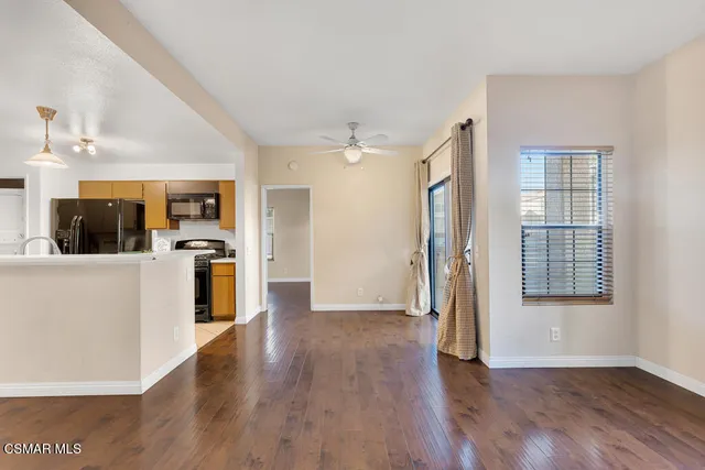 a view of a kitchen with a sink a refrigerator and wooden floor