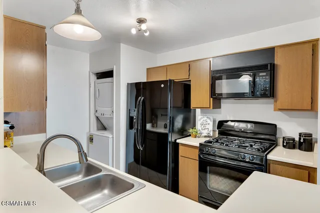 a kitchen with stainless steel appliances granite countertop a refrigerator a stove a sink and a microwave