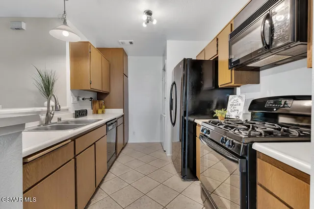 a kitchen with stainless steel appliances a sink stove and refrigerator