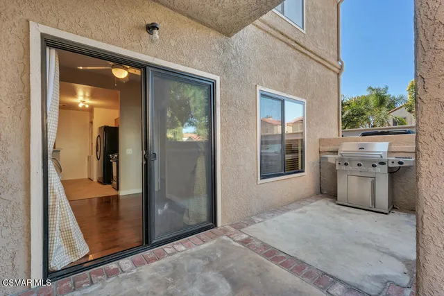 a view of a hallway with wooden floor and a kitchen