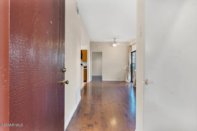 a view of a hallway with wooden floor