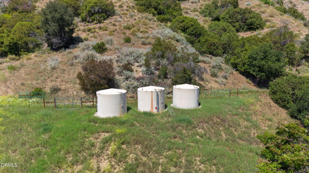 8416 Wheeler Canyon Road Santa Paula, CA 93060 - Photo 29 of 48 a view of a white and white house with yard and large trees
