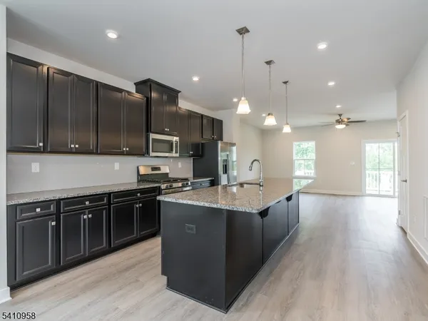 a large kitchen with stainless steel appliances lots of counter space sink and wooden floor