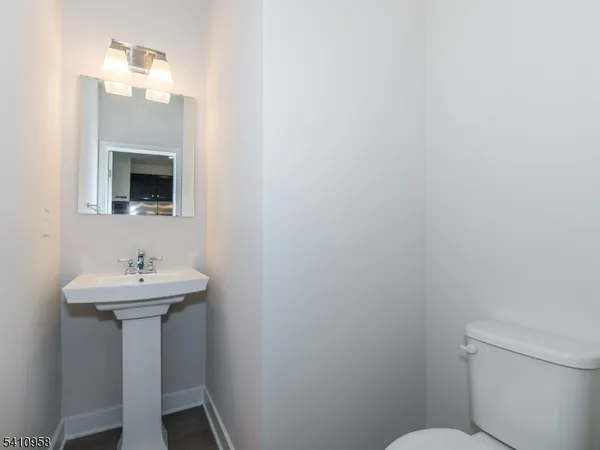 a bathroom with a sink toilet and a mirror